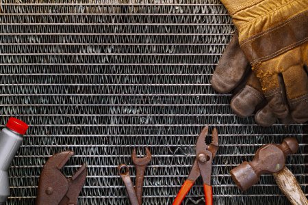 Vieux outils rouillés sur grille de radiateur métallique avec espace de copie