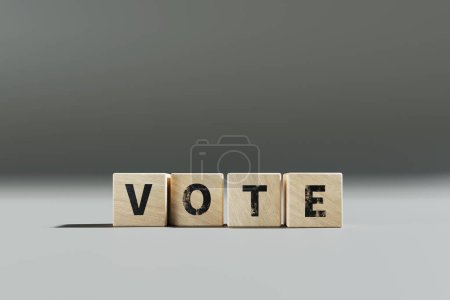 Téléchargez les photos : Un petit cube en bois avec le mot vote écrit dessus. - en image libre de droit