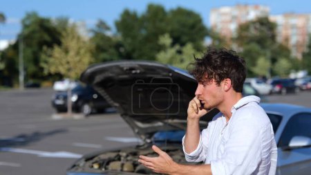 Photo for Upset man calling by smartphone to a car service near a broken car in the city outdoors. Car repair. Transport and lifestyle concept. Slow motion - Royalty Free Image