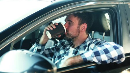 Un joven sentado en el coche mientras bebía café. Transporte, estilo de vida, concepto de personas