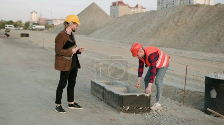 Constructeur mesurant blocs de béton sur le chantier, architecte processus de contrôle. Mouvement lent