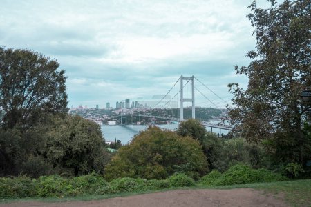 Foto de Hermosa vista del Bósforo desde el Parque Nakkastepe, un paisaje de Estambul con cielo nublado, puente entre árboles, paisaje urbano con mar, viajes en Estambul, Fatih Sultan Mehmet Bridge - Imagen libre de derechos
