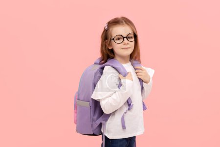 Photo for Portrait of a schoolgirl with textbooks and a backpack on a pink background. Back to school - Royalty Free Image