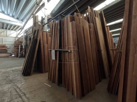 Foto de Madera aserrada con tableros verticales de madera tropical en un almacén industrial para la venta al público. - Imagen libre de derechos