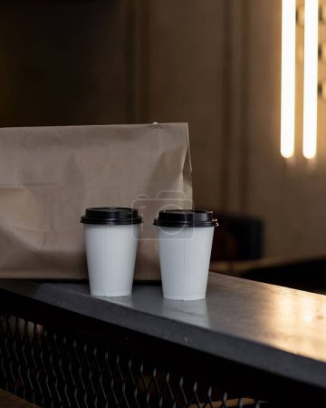 Téléchargez les photos : Deux tasses de café avec sac en carton, emporter de la nourriture, livraison de café à emporter, sur fond chaud de table en béton, Mexique Amérique latine - en image libre de droit