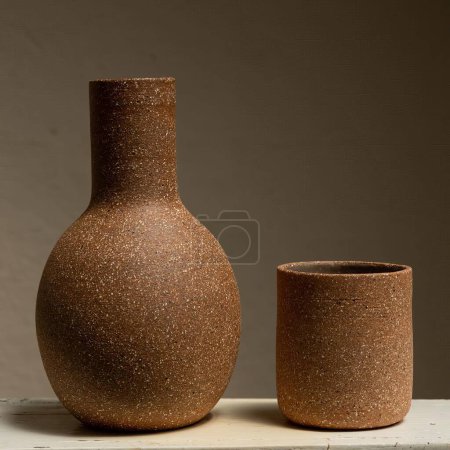 Foto de Recipiente de barro y cerámica encaramado en una base, jarrón para agua potable sobre un fondo neutro mexico latin america - Imagen libre de derechos
