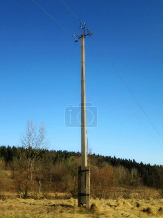 Concrete power line pole against a clear blue sky