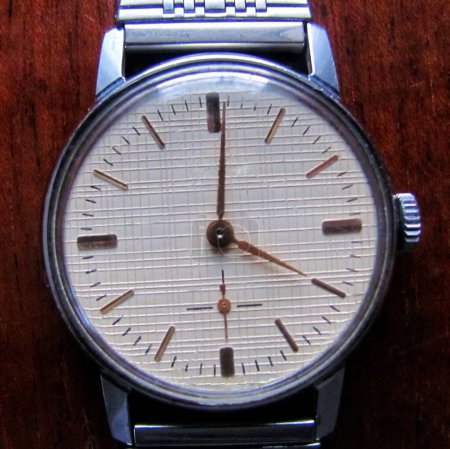 Close-up view of an old mechanical watch with a textured dial                               