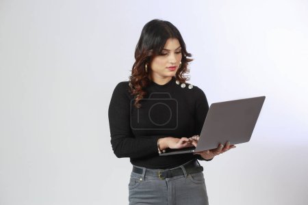 Téléchargez les photos : Jeune adulte et confiant fille hispanique à l'aide d'un ordinateur portable. - en image libre de droit