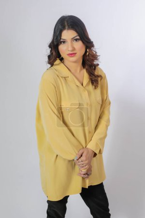 Téléchargez les photos : Jeune femme sexy en chemise jaune sur fond blanc - en image libre de droit