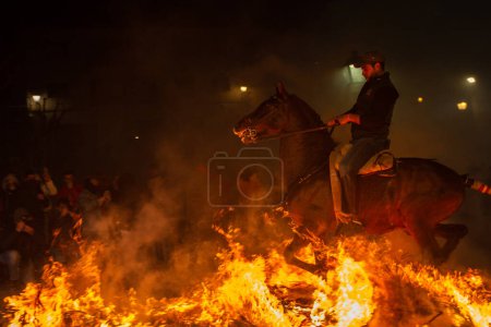 Photo for 16 January 2024, Knights cross bonfires with their horses in an ancient tradition of purification, "Las Luminarias Festival" in San Bartolome de Pinares, Avila, Spain. - Royalty Free Image