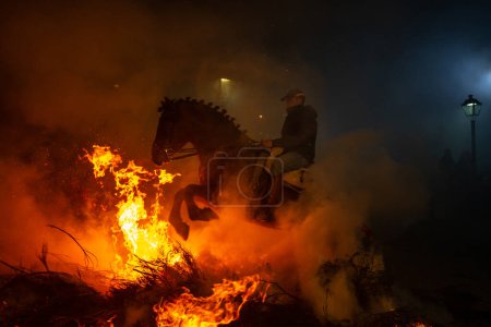 Foto de 16 Enero 2024, Caballeros cruzan hogueras con sus caballos en una antigua tradición de purificación, "Las Luminarias Festival" en San Bartolomé de Pinares, Ávila, España. - Imagen libre de derechos