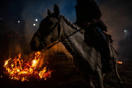 Photo for 16 January 2024, Knights cross bonfires with their horses in an ancient tradition of purification, "Las Luminarias Festival" in San Bartolome de Pinares, Avila, Spain. - Royalty Free Image