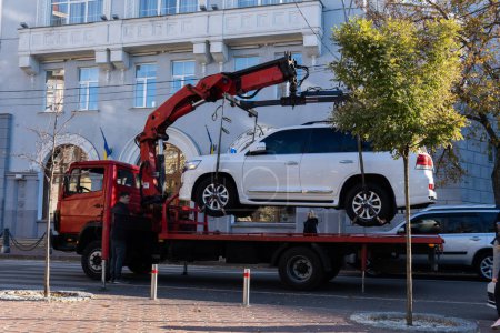 Photo for Kyiv, Ukraine, October 16, 2022. Wrecker towing car, vehicle fined for parking violations, evacuation service - Royalty Free Image