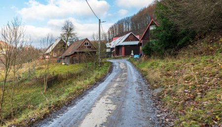 Photo for Kycera hamlet with few older wooden houses in Javorniky mountains in Slovakia during late autumn day - Royalty Free Image
