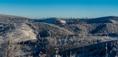 Colinas más cercanas de las montañas Beskid y la montaña Tatra en el fondo durante el día de invierno con cielo despejado - vista desde la ruta de senderismo a la colina Velka Raca