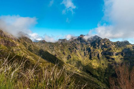 Steile, grüne und felsige Berge auf Madeira - Blick vom Vereda do Encumeada Wanderweg zwischen dem Encumeada Pass und dem Pico Ruivo Hügel an einem schönen Frühlingstag
