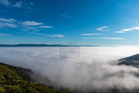 Hills above mist - view from Slavenska vyhlidka in Broumovske steny in CHKO Broumovsko in Czech republic during autumn morning