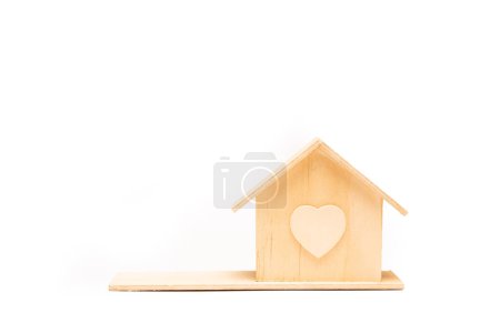 Téléchargez les photos : Little wooden house on white background. Eco-friendly house concept. Real estate investment concept. isolated. Wooden house model with copy space on the right. - en image libre de droit