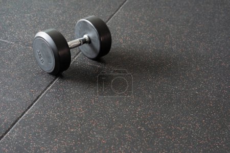 Black dumbbell. Weight Training Equipment. black dumbbells on the floor in dark concept fitness room with training equipments