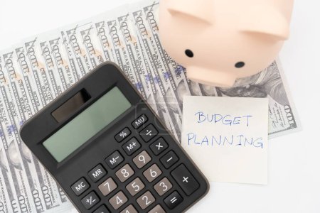 Téléchargez les photos : Money budget planning. Piggy bank with calculator on Dollars in isolated background. Finance and business concept. - en image libre de droit