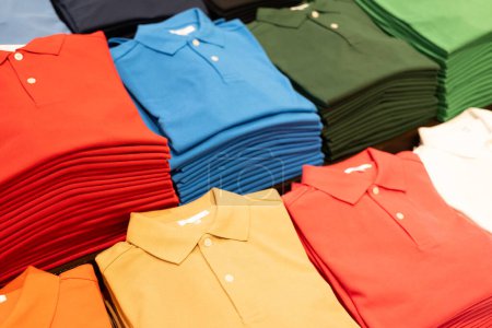 Mehrfarbige Kleidung, Poloshirt, Hemd. Poloshirt in verschiedenen Farben im Regal.