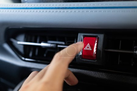 Photo for Presses the emergency stop button in the car. Car emergency warning light button in front car console. - Royalty Free Image