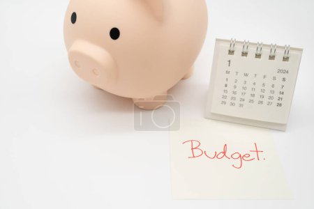 Photo for BUDGET text on paper, Piggy bank with 2024 JAN calendar on a white background. Finance, money management concept. - Royalty Free Image
