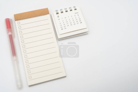 Leere Checkliste oder Leerer kleiner Notizblock mit Häkchen und Einfachem Schreibtischkalender für APRIL 2024. Leere Checkliste für Text. Kopierraum.