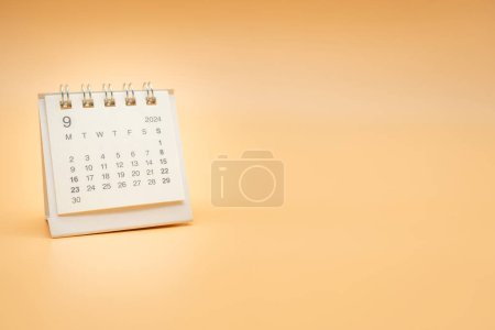 Simple desk calendar for September 2024 isolated on orange background. Calendar concept with copy space.