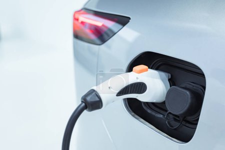 EV Car or Electric car at charging station with the power cable supply plugged. EV charging station for electric car in concept of green energy and eco power produced.