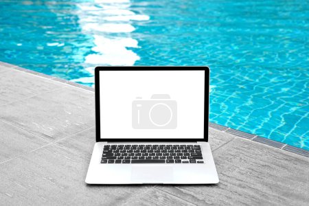 Photo for Laptop with blank screen for creative design on floor nearby swimming pool edge background. Computer notebook with monitor clipping path for present landing page design. Laptop computer mock up template - Royalty Free Image