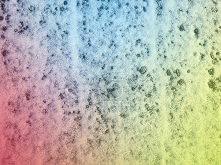 Foto de Dirty grunge texture of a small layer of snow on the asphalt painted with gradients of red, yellow and blue. Concrete urban overlay background, stencil, backing, overlay. Distress design template - Imagen libre de derechos