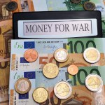 Money for war A calculator surrounded by euro bills and coins. The concept of militarization, increased spending on weapons for defense, the army, military training, the fight against terrorism