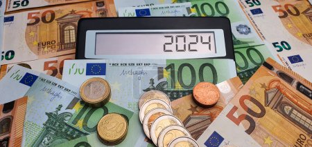 Elections and new challenges in 2024. Calculator on the background of 50 and 100 euro banknotes. Inflation, economic crisis, war, recession, migrants, cost of living, bills, poverty, infrastructure