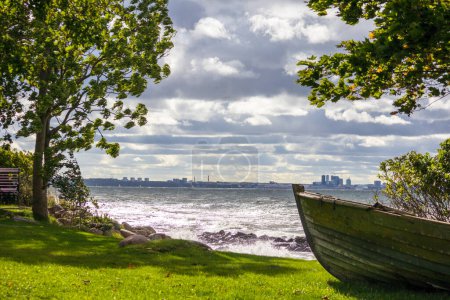 Foto de El arco de un barco de madera en la orilla sobre el fondo de la ciudad y el mar - Imagen libre de derechos