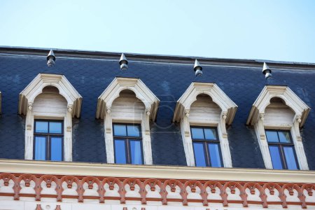 Téléchargez les photos : La façade du bâtiment avec des rangées égales de fenêtres sur les tours du toit ; - en image libre de droit