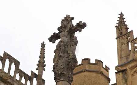 Foto de Una cruz de piedra de Jesús adorna la histórica iglesia de San Juan Bautista en Cotswold Cirencester - Imagen libre de derechos