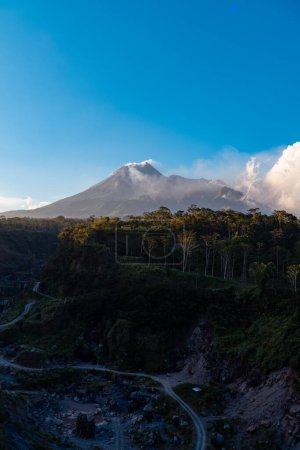 La beauté du mont Merapi au crépuscule avant la tombée de la nuit avec une falaise de lave froide coule juste en face de lui. Le mont Merapi semble détaillé par temps clair avec un ciel bleu et des nuages à côté
