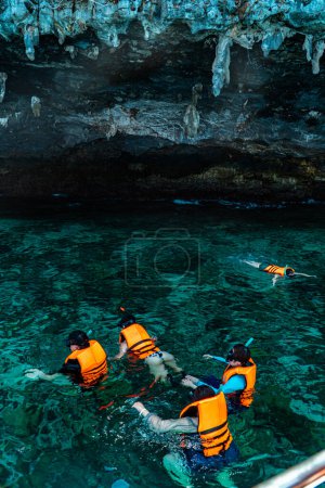 Téléchargez les photos : La beauté de la vaste mer et de voir le biote dans l'eau en faisant de la plongée avec tuba à l'aide d'un google et un gilet de sauvetage. plongée avec tuba autour de l'île Phi-phi, Mueang Krabi, Thaïlande avec une vue charmante sur la falaise rocheuse - en image libre de droit