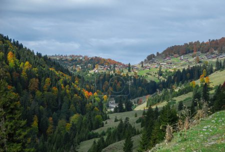 Téléchargez les photos : En automne, au milieu des paysages pittoresques des montagnes géorgiennes, se dresse un village avec des maisons en bois. - en image libre de droit