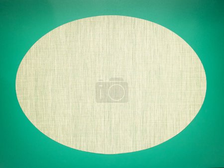Photo for Mocap, oval vignette of a textured gray-green fabric on a dark green background. Space for text. - Royalty Free Image