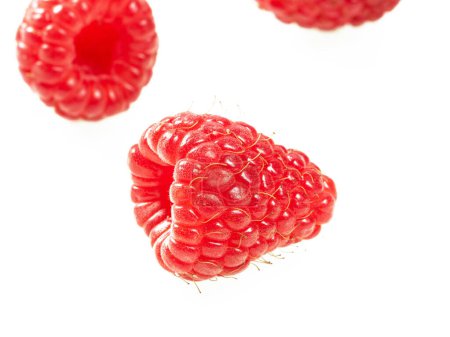 Three ripe raspberries close-up on a white background.