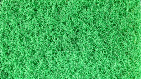 Foto de Un primer plano de un tejido verde texturizado con patrones sutiles, proporcionando un fondo versátil y abstracto para proyectos de diseño, texturas y aplicaciones creativas. - Imagen libre de derechos