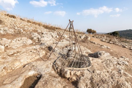Photo for Karmiel, Israel, October 28, 2022 : Replica of old metal well on territory of ancient Jotapata city, was located during Roman Empire ancient Jotapata, in Tel Yodfat National park, in northern Israel - Royalty Free Image
