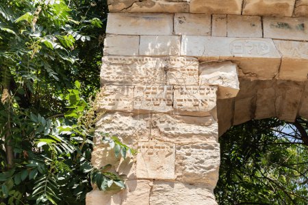 Photo for The ruins of an old stone building with Hebrew words carved in stone on a quiet street in the old part of Safed city in northern Israel - Royalty Free Image