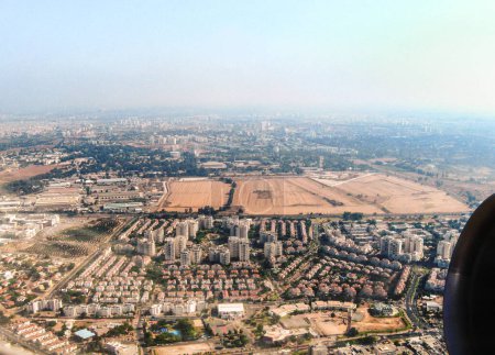 View from the window of an airplane taking off from Ben Gurion Airport and flying over Tel Aviv city in Israel towards the Mediterranean Sea and Europe