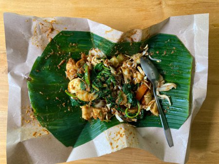 Foto de Pecel Lontong o generalmente llamado Lotek, es un alimento tradicional indonesio hecho de una mezcla de verduras hervidas mezcladas con salsa de maní. - Imagen libre de derechos