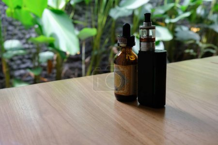 Téléchargez les photos : Vape et e-cigarette liquide sur table en bois - en image libre de droit