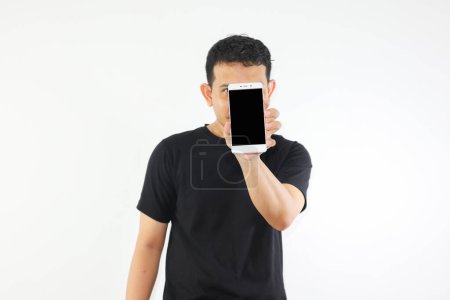 Foto de Adulto asiático hombre mostrando en blanco teléfono móvil pantalla que cubre su cara - Imagen libre de derechos
